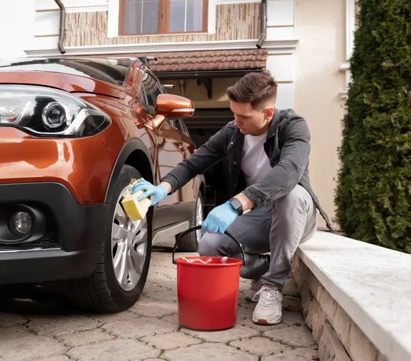 Lavage auto à domicile Thézan-des-Corbières : professionnel intervenant sur un véhicule